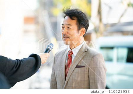 街頭インタビューに答える男性 街頭インタビューに答える男性 110525958