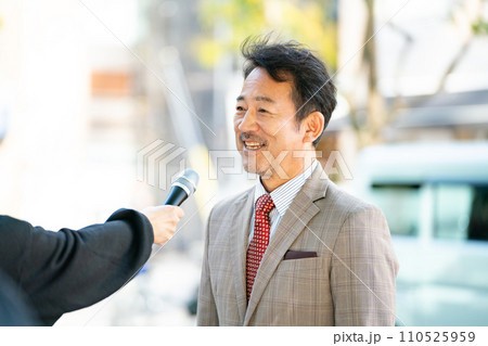 街頭インタビューに答える男性 110525959