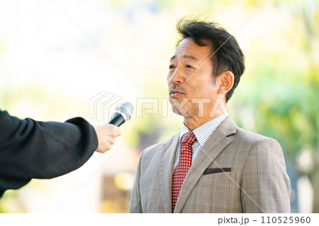街頭インタビューに答える男性 街頭インタビューに答える男性 110525960
