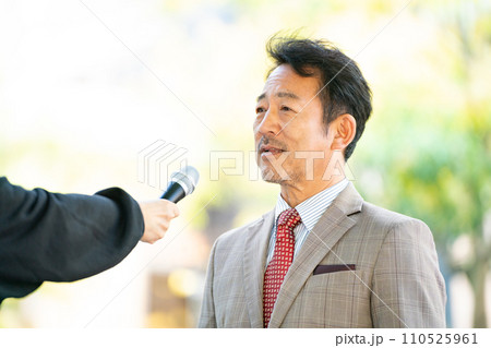 街頭インタビューに答える男性 110525961