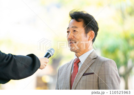 街頭インタビューに答える男性 110525963