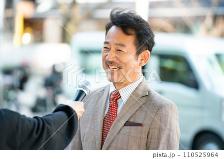 街頭インタビューに答える男性 110525964