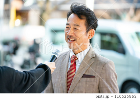 街頭インタビューに答える男性 110525965