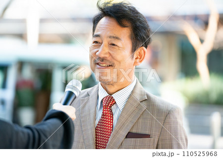 街頭インタビューに答える男性 110525968