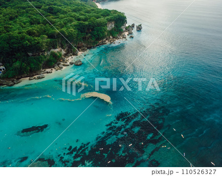 Padang Padang beach in Bali and plastic trash in ocean. Ocean pollution, plastic in water. Aerial view. Padang Padang beach in Bali and plastic trash in ocean. Ocean pollution, plastic in water. Aerial view. 110526327