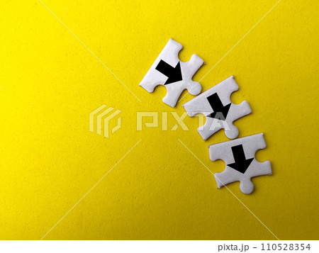 Top view white puzzle with arrow icon on a yellow background. Top view white puzzle with arrow icon on a yellow background. 110528354