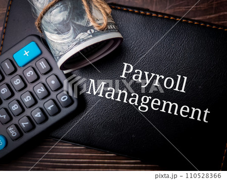 Top view calculator and banknotes with text Payroll Management on wooden background. 110528366