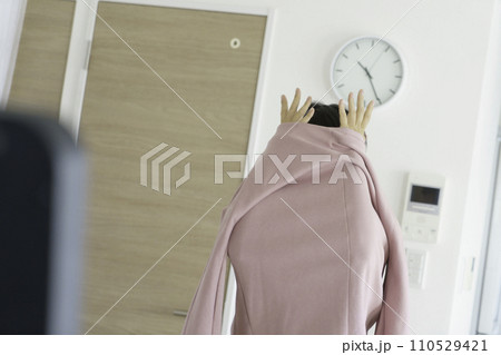 着替え中、服から手をだす若い女性 着替え中、服から手をだす若い女性 110529421