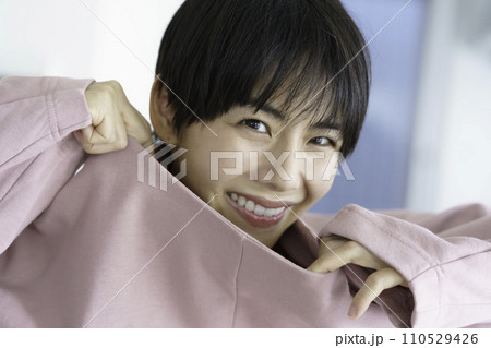 服から首を出して笑う若い女性 110529426