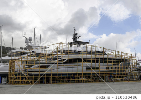 Luxury super yacht ashore on ship repairing yard. Yard period. Repairing. Motor yacht. Luxury super yacht ashore on ship repairing yard. Yard period. Repairing. Motor yacht. 110530486