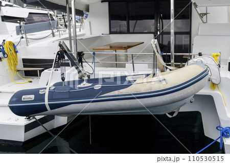 Inflatable tender motor boat on swim platform of superyacht. Inflatable dinghy with outboard engine. Power boat. Inflatable tender motor boat on swim platform of superyacht. Inflatable dinghy with outboard engine. Power boat. 110530515