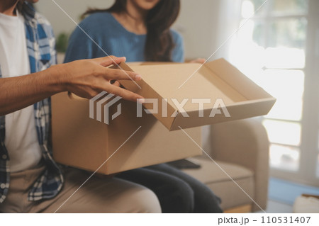 Two Asian blogger showing clothes in front of the camera to recording vlog video live streaming at her shop. Online Shopping Cart notion. on sofa at home 110531407