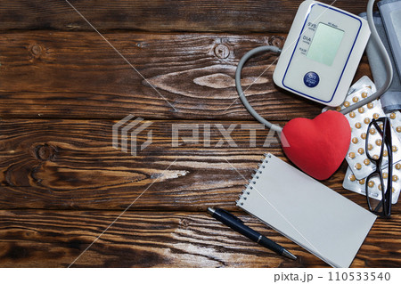 Red heart on the background of pills. Concept of health, heart disease. Red heart on the background of pills. Concept of health, heart disease. 110533540