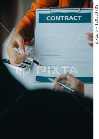 Closeup asian male people car salesman or sales manager offers to sell a car and explains and reads the terms of signing a car contract and insurance. 110533785