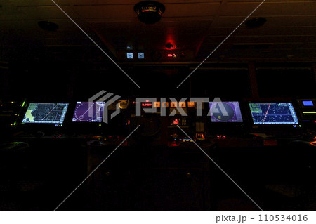 Navigational bridge on big cargo ship. Wheelhouse on vessel. ECDIS, radar. Night time. Navigational bridge on big cargo ship. Wheelhouse on vessel. ECDIS, radar. Night time. 110534016
