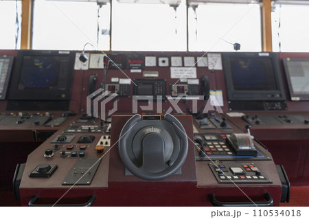 Ship's control device. Engine control from navigational bridge. Focused on helm, blured background. Ship's control device. Engine control from navigational bridge. Focused on helm, blured background. 110534018