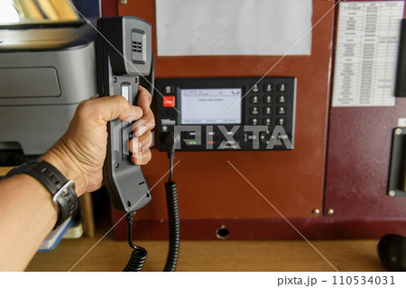 Navigational control panel and VHF radio with hand. Radio communication at sea. Working on the ship's bridge. Navigational control panel and VHF radio with hand. Radio communication at sea. Working on the ship's bridge. 110534031