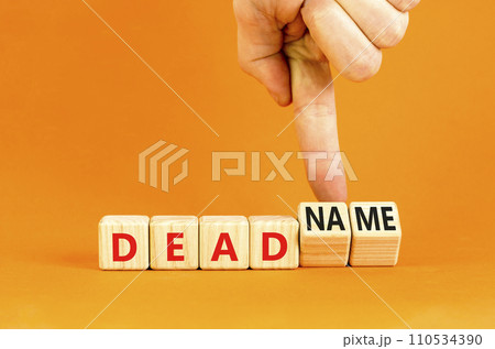 Deadname or name symbol. Concept words Deadname or Name on beautiful wooden blocks. Beautiful orange table orange background. Transgender hand. Business, deadname or name concept. Copy space. Deadname or name symbol. Concept words Deadname or Name on beautiful wooden blocks. Beautiful orange table orange background. Transgender hand. Business, deadname or name concept. Copy space. 110534390