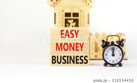 Easy money business symbol. Concept words Easy money business on beautiful wooden blocks. Beautiful white table white background. Black alarm clock. Easy money business concept. Copy space. 110534458