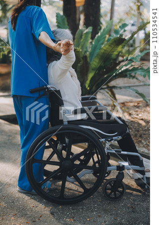 A nurse take care a senior male on wheelchair in his garden at home 110534541