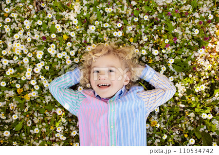 Child on green grass lawn with summer flowers 110534742