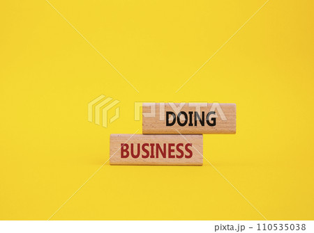Doing Business symbol. Concept word Doing Business on wooden blocks. Beautiful yellow background. Business and Doing Business concept. Copy space Doing Business symbol. Concept word Doing Business on wooden blocks. Beautiful yellow background. Business and Doing Business concept. Copy space 110535038