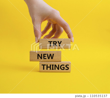 Try new Things symbol. Concept words Try new Things on wooden blocks. Businessman hand. Beautiful yellow background. Business and Try new Things concept. Copy space. 110535137
