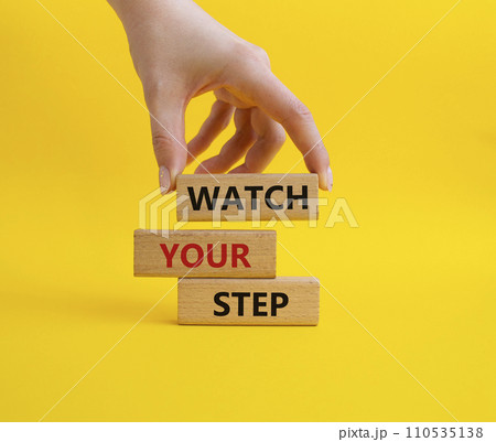 Watch your Step symbol. Concept words Watch your Step on wooden blocks. Businessman hand. Beautiful yellow background. Business and Watch your Step concept. Copy space. 110535138