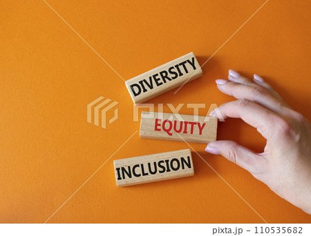Diversity Equity Inclusion symbol. Concept words Diversity Equity Inclusion on wooden blocks. Beautiful orange background. Businessman hand. Business and Diversity Equity Inclusion concept. Copy space 110535682