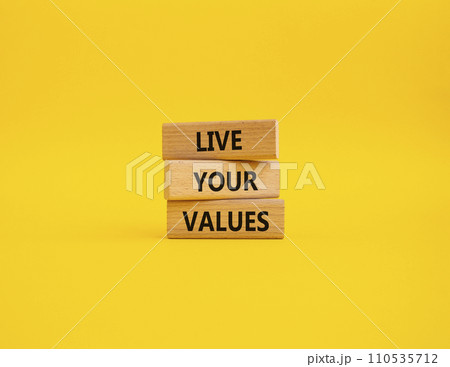 Live your values symbol. Concept words Live your values on wooden blocks. Beautiful yellow background. Business and Live your values concept. Copy space. 110535712