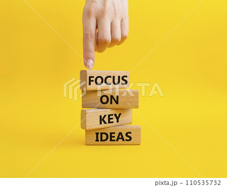 Focus on Key Ideas symbol. Concept words Focus on Key Ideas on wooden blocks. Beautiful yellow background. Businessman hand. Business and Focus on Key Ideas concept. Copy space 110535732