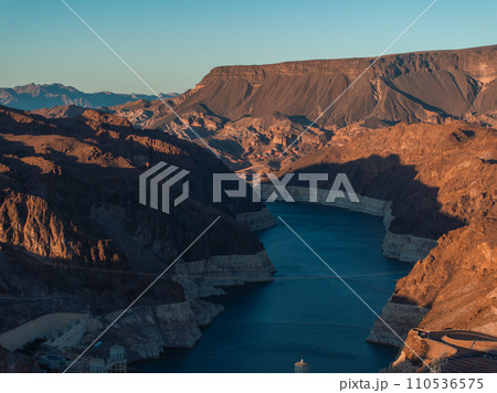 Hoover Dam on the Colorado River straddling Nevada and Arizona at dawn from above. Aerial view of Hoover Dam and the Colorado River Bridge Hoover Dam on the Colorado River straddling Nevada and Arizona at dawn from above. Aerial view of Hoover Dam and the Colorado River Bridge 110536575