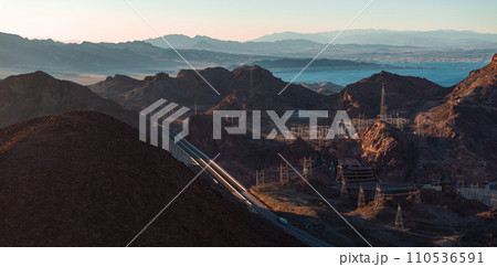Hoover Dam on the Colorado River straddling Nevada and Arizona at dawn from above. Aerial view of Hoover Dam and the Colorado River Bridge 110536591