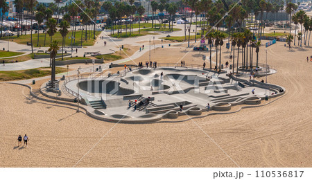 Skate board park in Venice beach with people skating by the Pacific ocean. Best and most popular skate park in the world. 110536817