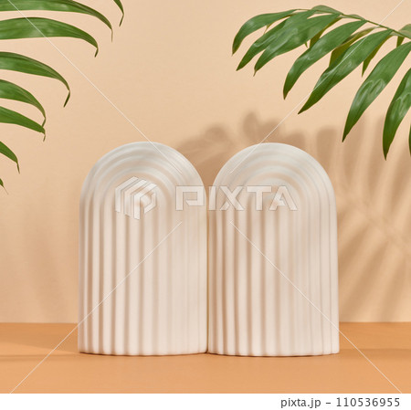 Abstract beige background with white decorative arch and palm leaf and shadow, stage for showcasing products, cosmetics 110536955