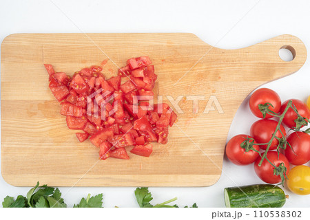 Top view of tomatoes cut into pieces for preparing a salad. Top view of tomatoes cut into pieces for preparing a salad. 110538302