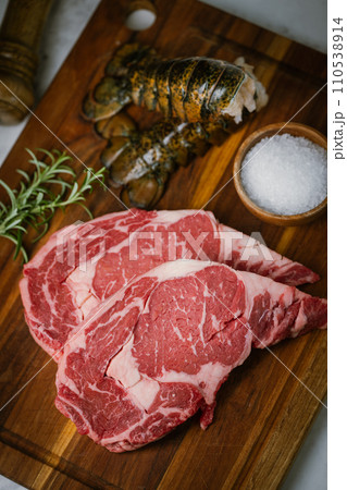 fresh ribeye steak and lobster tail on white marble background 110538914