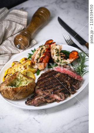 surf and turf, ribeye steak and lobster tail on white marble background 110539450