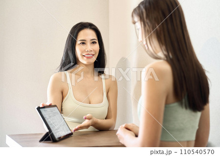 ジムでカウンセリングを行うトレーナー ジムでカウンセリングを行うトレーナー 110540570