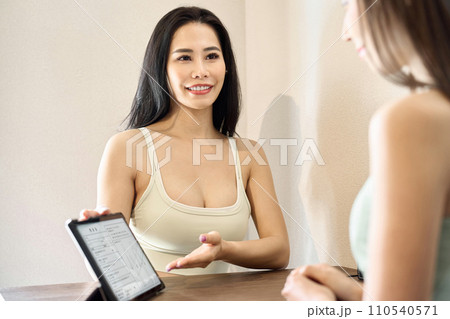 ジムでカウンセリングを行うトレーナー 110540571