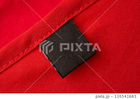 Blank black laundry care clothes label on red fabric texture background 110541663