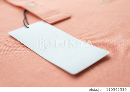 Blank white clothes tag label on pink fabric texture background 110542536