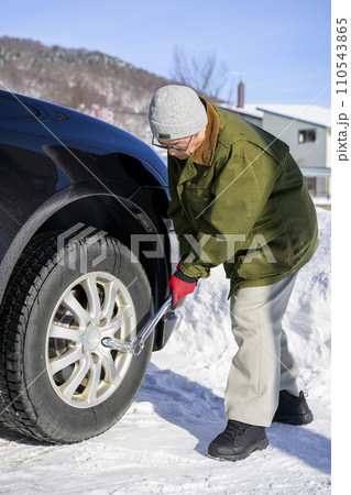 タイヤのナットをトルクレンチで締める男性 タイヤのナットをトルクレンチで締める男性 110543865