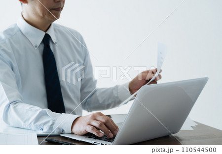 帳簿を確認する男性ビジネスマンの手元 帳簿を確認する男性ビジネスマンの手元 110544500