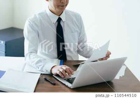 帳簿を確認する男性ビジネスマンの手元 帳簿を確認する男性ビジネスマンの手元 110544510