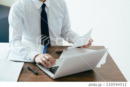 帳簿を確認する男性ビジネスマンの手元 110544512