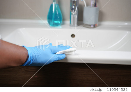 Hand in gloves cleaning the bathroom 110544522