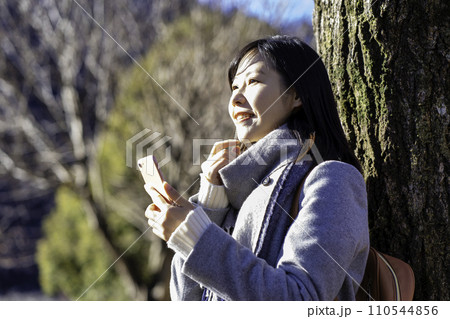 冬の公園でスマホを使う女性 冬の公園でスマホを使う女性 110544856