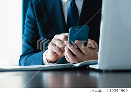 スマホでメールを送るビジネスマンの手元 110544960