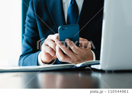 スマホでメールを送るビジネスマンの手元 110544961